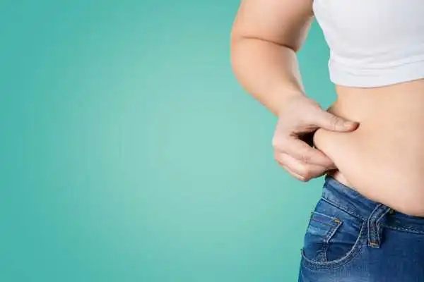 Image of woman pinching her love handles to show weight gain Islington