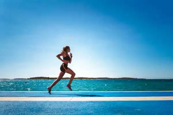 Woman running showing strong leg muscle Islington